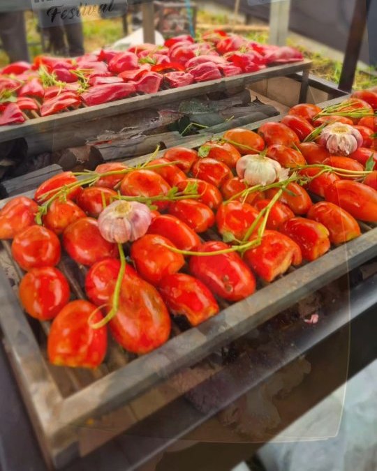 Estação de buffet com carnes e tomates assando na brasa